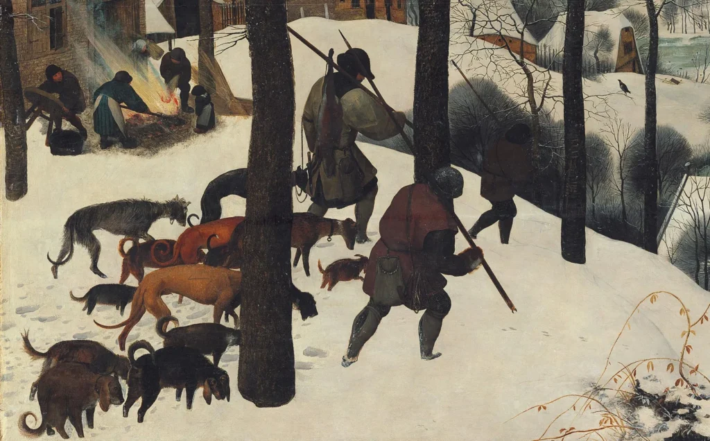 Paisaje invernal con cazadores regresando con perros hacia un pueblo cubierto de nieve, río helado y figuras patinando al fondo, obra de Pieter Brueghel el Viejo.