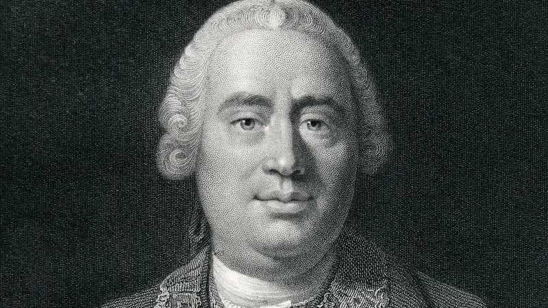 Retrato grabado en blanco y negro del filósofo escocés David Hume, mostrado de frente con peluca del siglo XVIII sobre fondo oscuro.